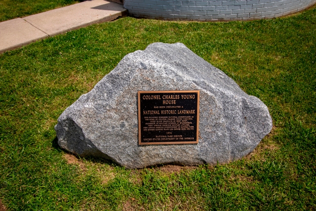 A large gray stone boulder with a bronze plaque on it indicating a national historical landmark