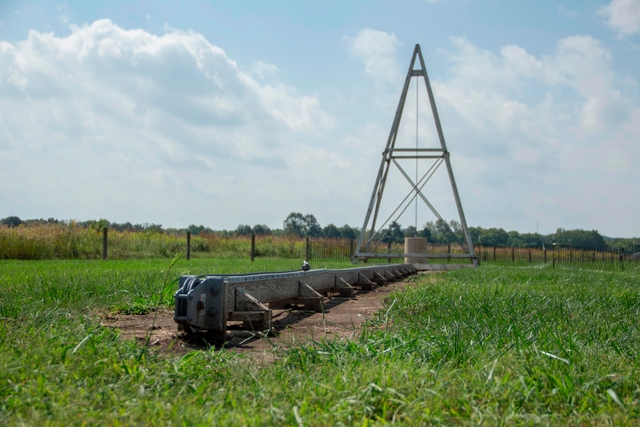 A long wood and steel rail leading to a pyramid tower structure in the background.