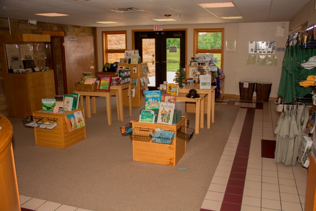 Several square pedestals hold books and other gifts in the middle of a carpeted floor