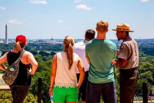 A park ranger talks to people overlooking Washington, DC