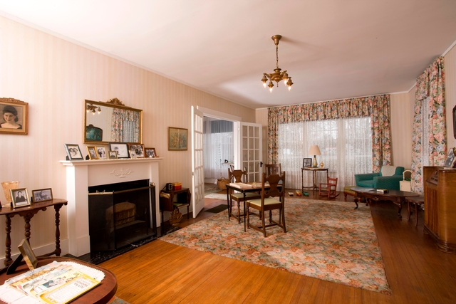 A view of the living room with a fireplace, rug, recliner and other furniture