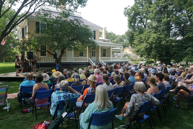 large crowd on the east lawn listening to singers perfom