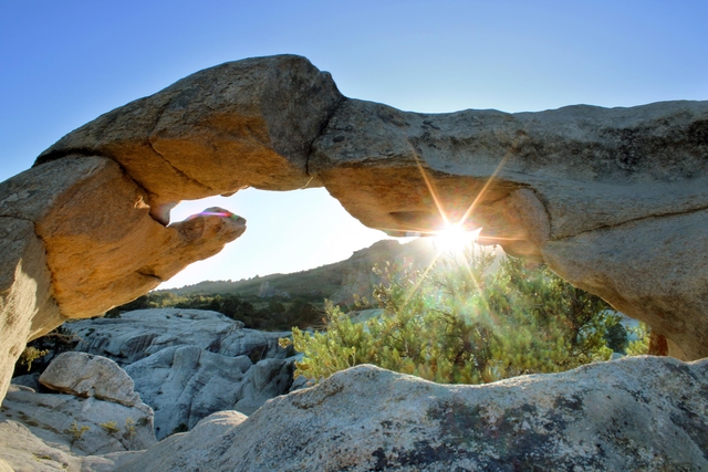 Granite arch with sunset peeking through.