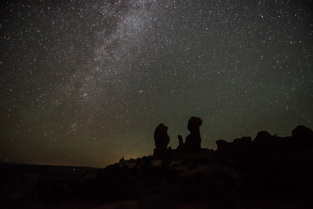 the Milky Way arcs above silhouetted stone pinnacles