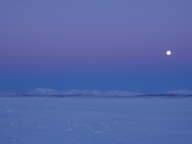 moon over snow covered hills