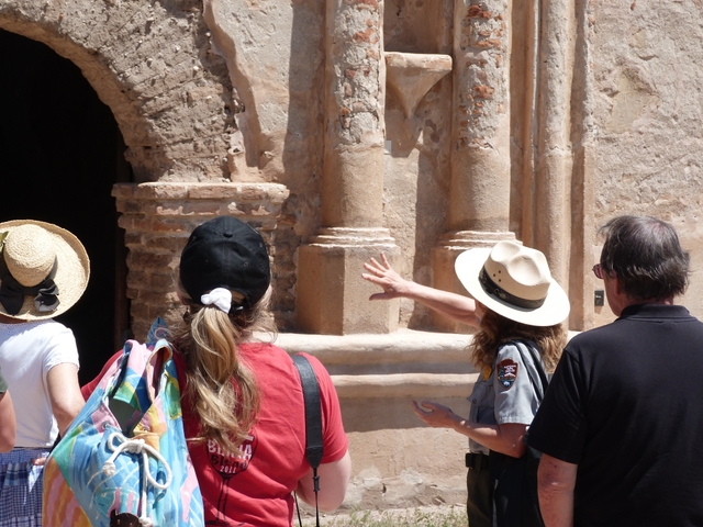 ranger and visitors looking at church facade