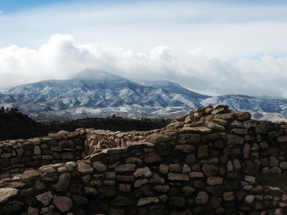 4 foot masonry walls with mountains and clouds behind them.