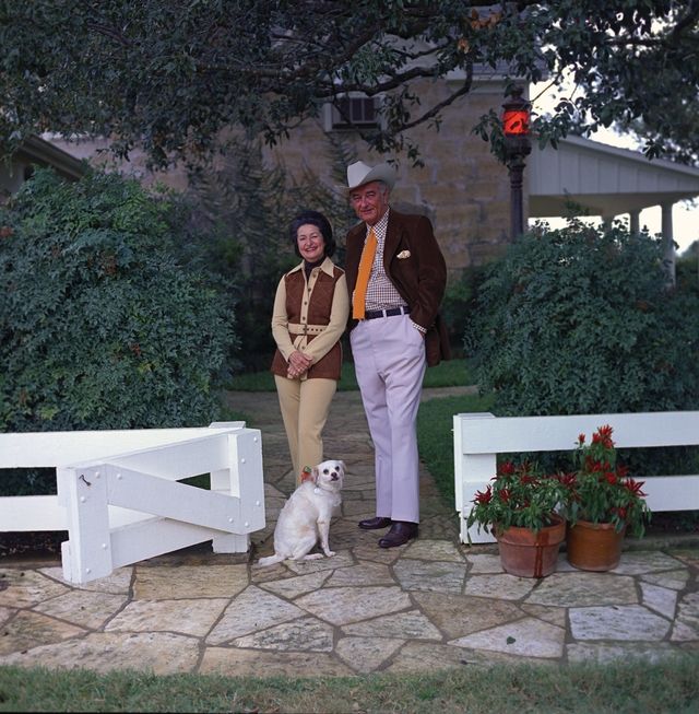 President and Mrs. Johnson stand outside the Texas White House with dog Yuki.