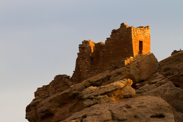 a stone structure resting on a cliff edge