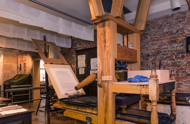 A color photo of a printing press in the Franklin Court Printing Office.