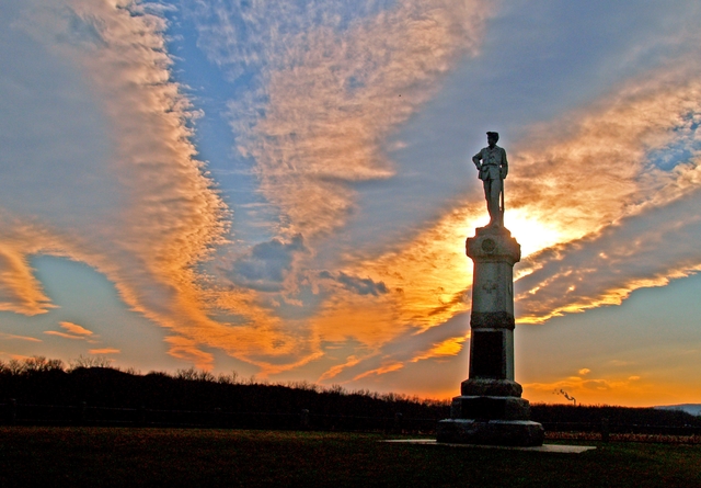 The sun setting behind a monument.