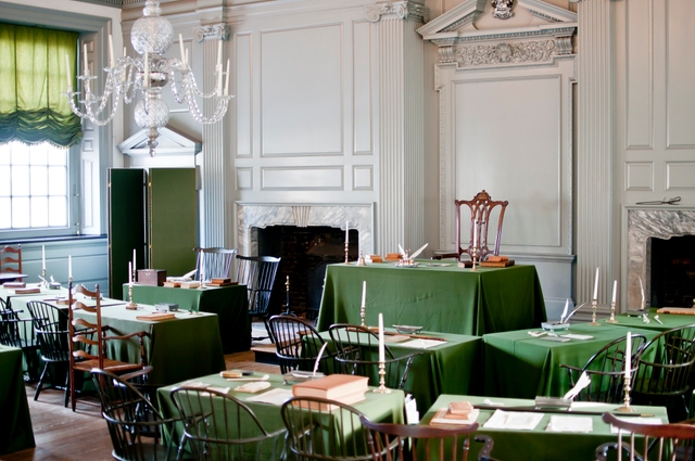 A color photo of the Assembly Room showing 18th century chairs and green, cloth covered tables