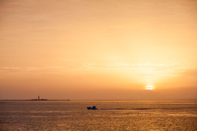 A boat passes in front of Loggerhead Key during sunset.