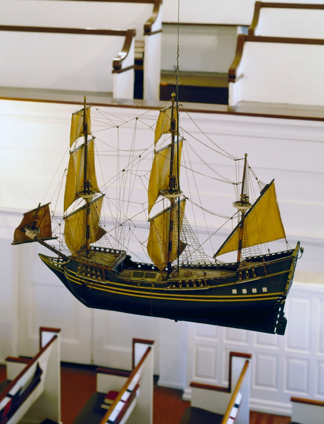 A color photo of a model tall ship hanging inside Gloria Die Church.