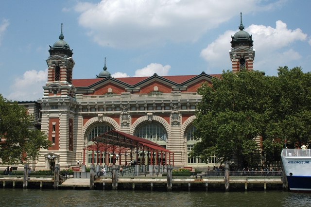 Beaux-Arts brick and limestone building with large arched windows and cupola-topped towers.