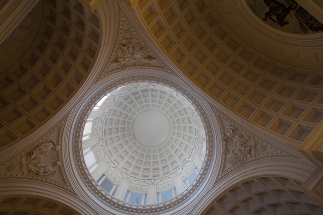 A circular dome is held up by carvings of allegorical figures.