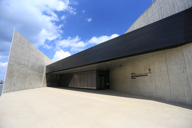 Tall gray walls with a black metal overhang and glass walls
