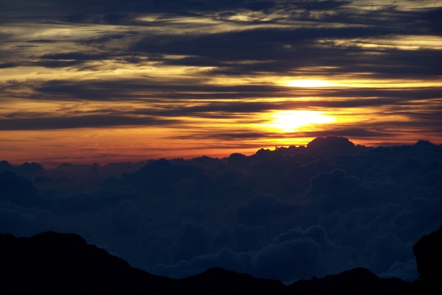 Sun setting over the volcano crater and horizon