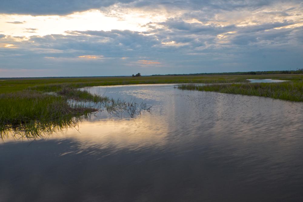 Winding river surrounded by grasslands on a cloudy day.