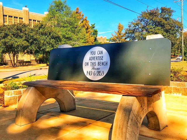 a replica of a 1950s bus bench with Central High School in the background