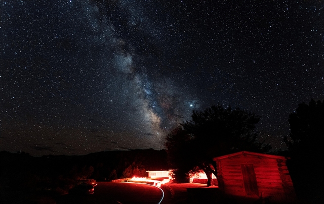 Colorful Milky Way over the red lit Lehman Caves Visitor Center