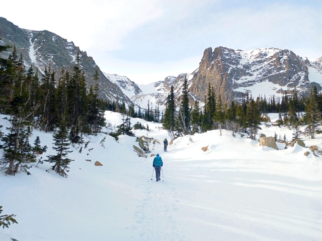 Two people are snowshoeing in the snow