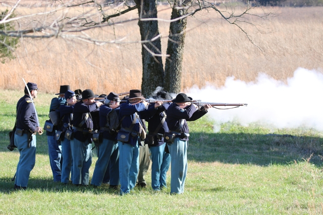 Union soldiers fire muskets.