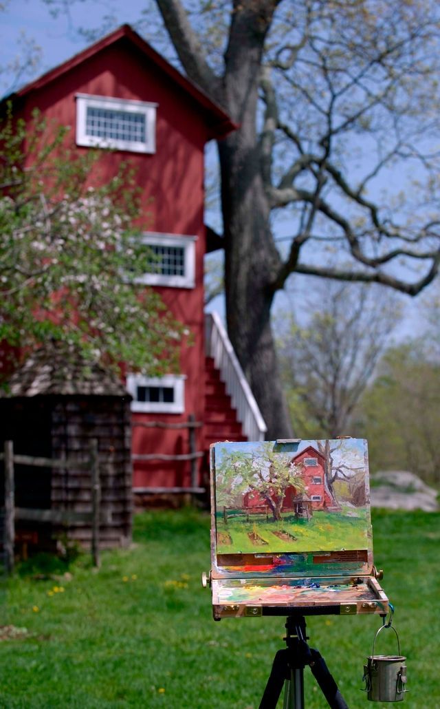 A painting of a red building with the same building in the background.