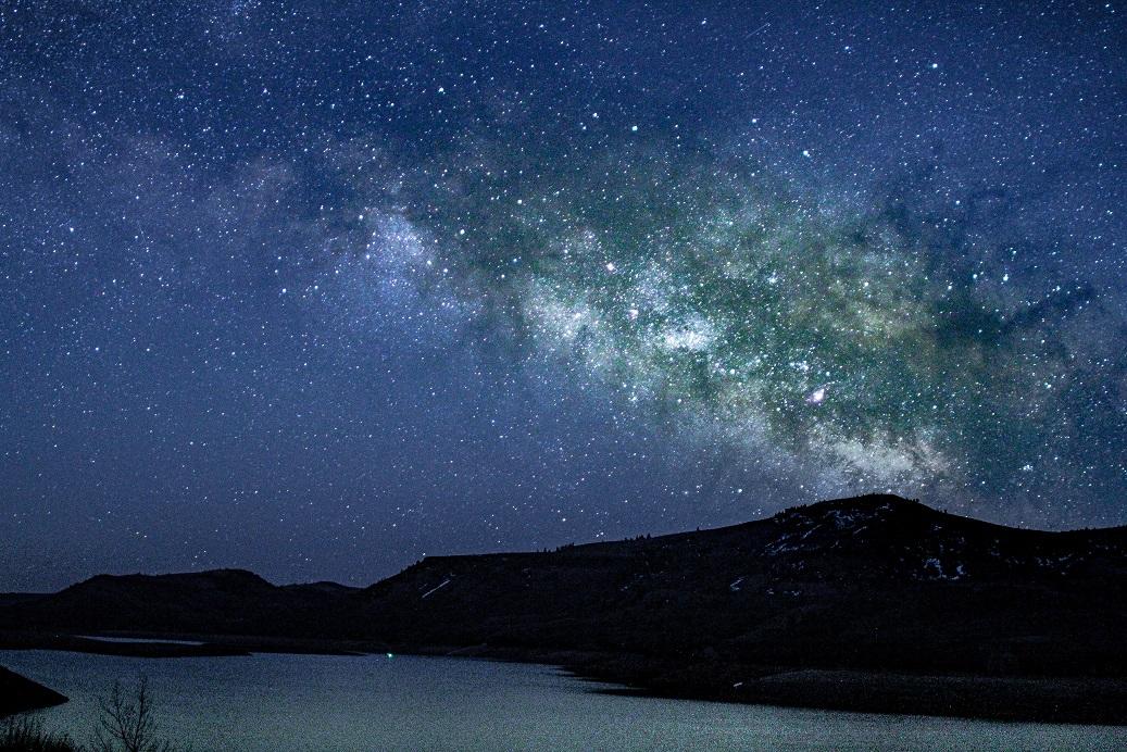 An arm of the Milky Way galaxy glows over Blue Mesa.