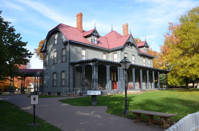 a large gray house with a red roof