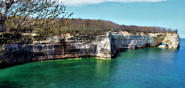 Mineral stained cliffs and collapsed rock arch along Lake Superior