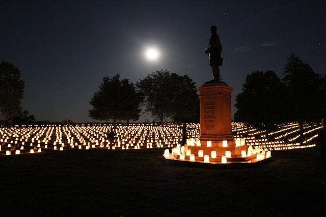 Monument in national cemetery illuminated by candles
