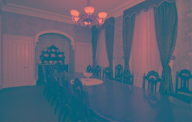 Colored photograph of a long, narrow dining room