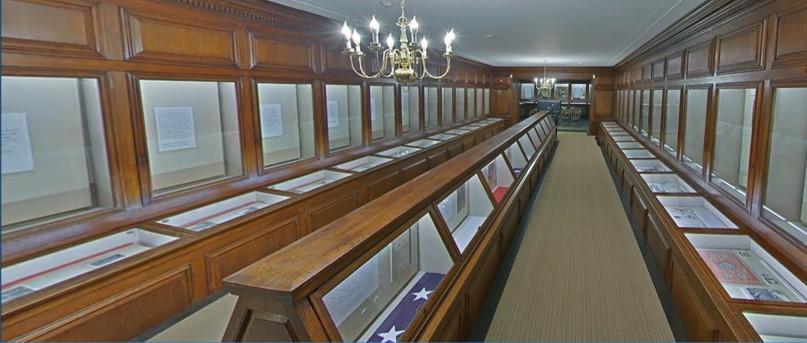 Photo of exhibit hallway with display cases on sides of room and running through center of room.