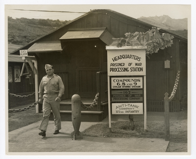 A historic photo of a soldier walking out of a barrack