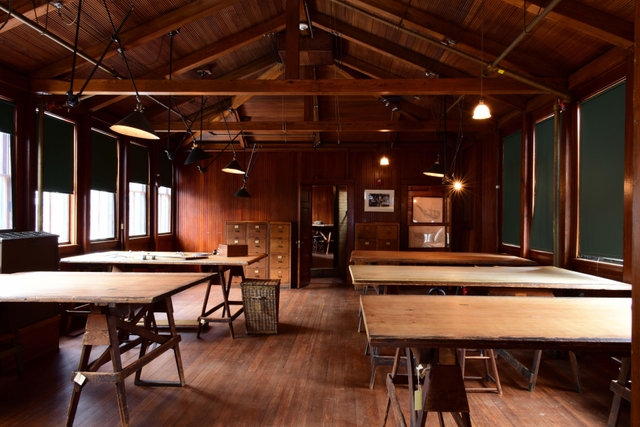 Large room with wooden tables and stools