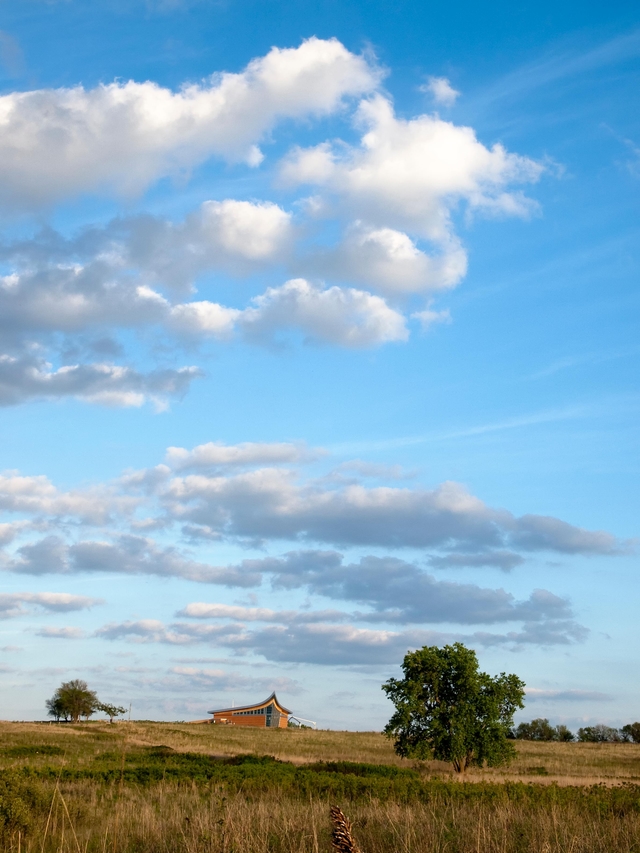 The tallgrass prairie spans to the Heritage Center on the horizon.