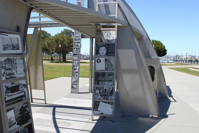 Modern art memorial structure with historic photos. Sits in park.
