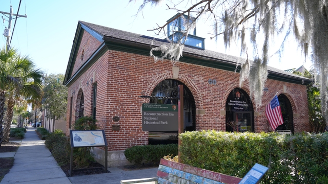 A one story brick building with large arched windows
