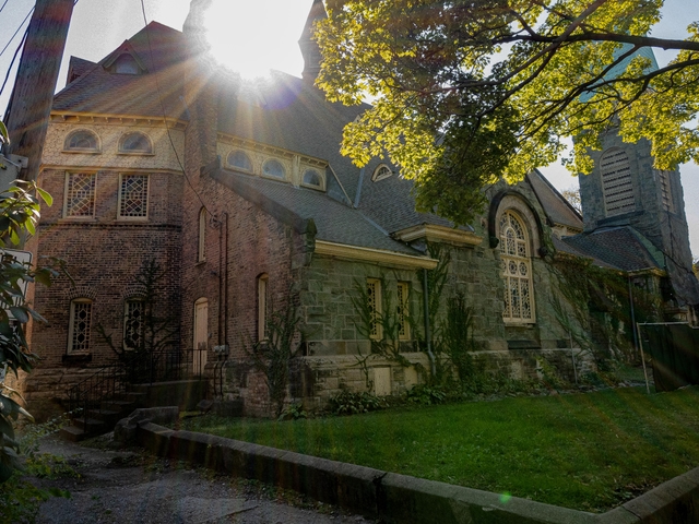 An image of the Greenstone Church with the sun peeking over the top of it